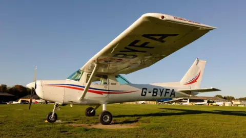 a Cessna 152, which is a small white plane, on an airfield