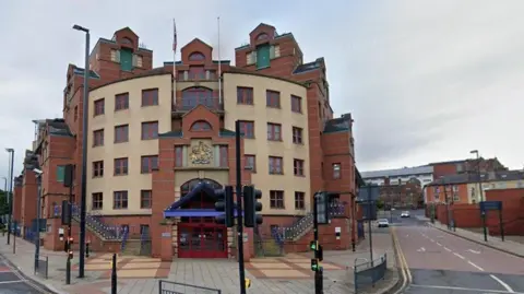 The outside of Leeds Magistrates' Court - a modern red-brick building.