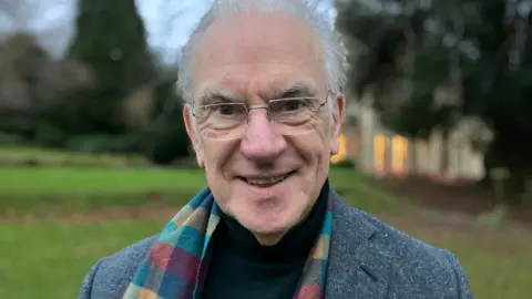 Malvern Hills leader John Gallagher stands outside in front of the council's headquarters at Priory Park