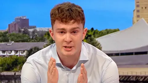 Archie Goodburn talks in a BBC studio with tears in his eyes about his cancer