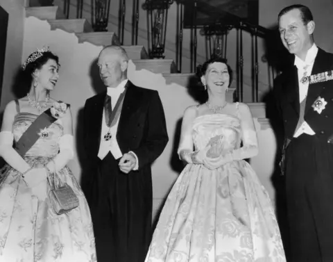 Keystone / Getty Images The Queen, wearing the apple green dress, a sash and a tiara, is pictured next to Eisenhower, his wife Mamie and Prince Philip in a black and white print.