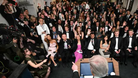 AFP via Getty Images White House guests who were dressed for the ballroom event attend the Press Briefing Room.