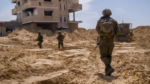 Israeli soldiers conducting operations in Gaza. The soldiers are wearnig camouflage military clothing and holding guns
