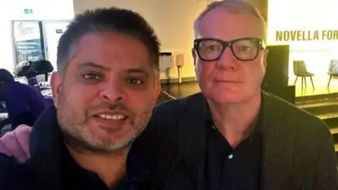 Richard Parker Waseem Zaffar on left and Richard Parker are standing next to each other with Parker's arm on Zaffar's shoulder