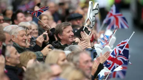 A crowd claps and waves union flags during the victory parade in Manchester following the 2016 Olympics and Paralympics.