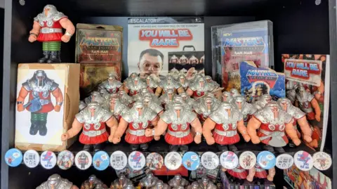 Amy Harrison A close-up shot of the Ram Man figures, badges and posters on a cabinet.