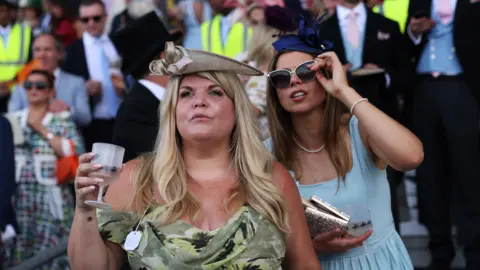 NEIL HALL/EPA/Shutterstock Two women watch a race on the first day of Royal Ascot.