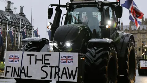 Getty Images A black  tractor with a sign saying "The Final Straw" is in front of Westminster. 