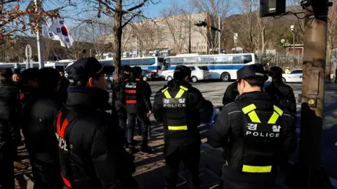 Reuters Police officers gather near the Corruption Investigation Office for High-ranking Officials as people await the arrival of impeached South Korean President Yoon Suk Yeo