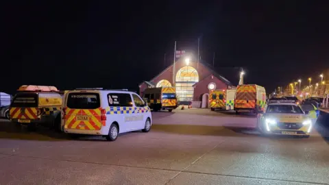 Ambulances and police outside the boathouse - in dark night