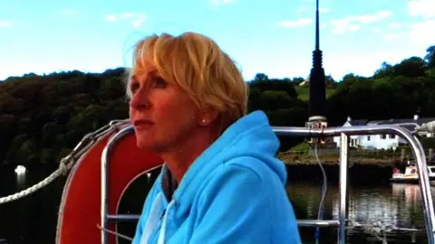 Sarah sitting on boat on lake