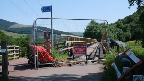 Jim Barton A bridge crossing fenced off with a sign advising pedestrians to use another footpath