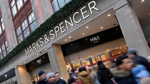 Exterior shot of a Marks and Spencer store with people walking past it