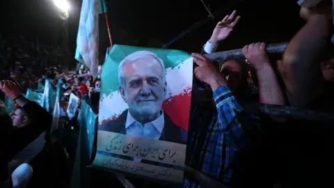 EPA Supporters clasp  a poster statesmanlike  campaigner  Dr Massoud Pezeshkian