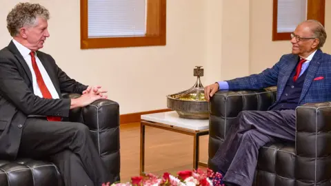 Mauritius government Jonathan Powell and Mauritian Prime Minister Navinchandra Ramgoolam sitting on leather chairs holding discussions