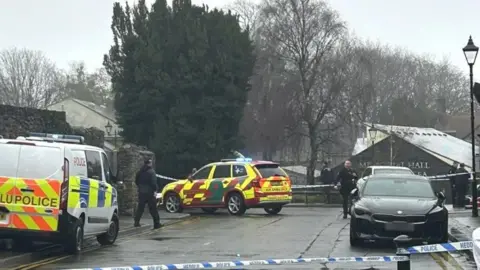 KATHRYN CHARLES The scene outside the property in Llandaff, showing police officers and vehicles and a police cordon