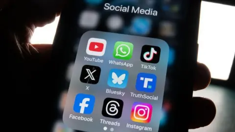 Getty Close up of a mobile phone screen showing icons for nine social media apps, including Facebook, Instagram and X.