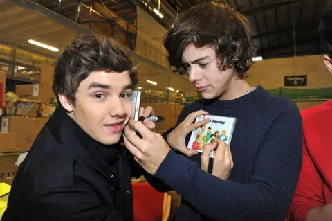 Getty Images Harry Styles signeert een cd op Liams gezicht