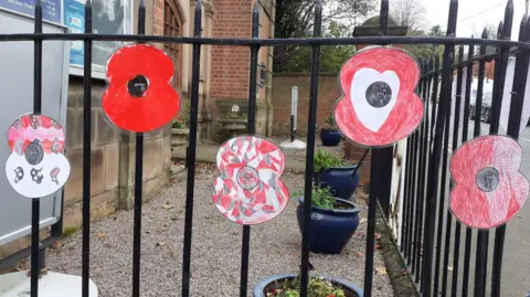 Shepshed Community Poppy project 2024. Paper poppies attached to railings.