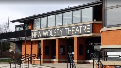 Google The entrance to the New Wolsey Theatre in Ipswich. There are steps and railings leading up to the entrance. It is a modern two-storey building