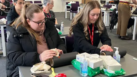 BBC Two girls learning how to stop bleeding with equipment