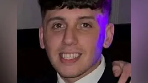 Police Scotland A smiling young man with dark hair cut short at the sides