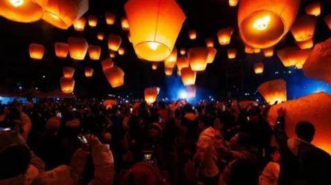 People launching lanterns into the night sky