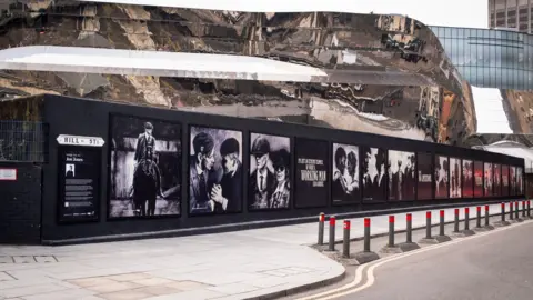 A series of black and white painted murals which depict the Peaky Blinders series and film.