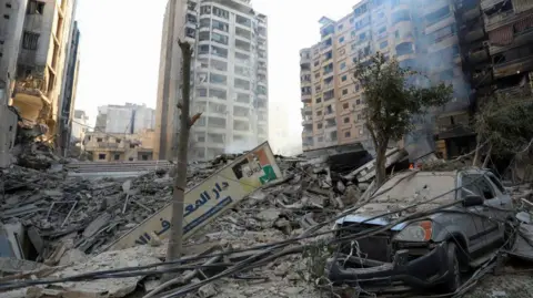 Reuters Buildings are damaged and a vehicle destroyed after an Israeli air strike on Beirut, Lebanon. Photo: October 27, 2024