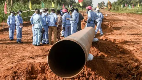 AFP Workers from Niger and China are seen on the construction site of an oil pipeline in the region of Gaya, Niger - October 2022