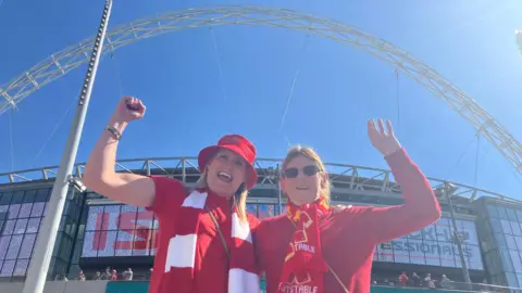 Jacob Panons/BBC Two women in their arms around each other in front of Wembley