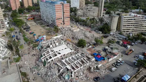 Reuters Some apartmentment blocks are still standing in this aerial shot, but others are completely flat on the ground, surrounded by rubble. Other buildings are leaning and look like they too could collapse.