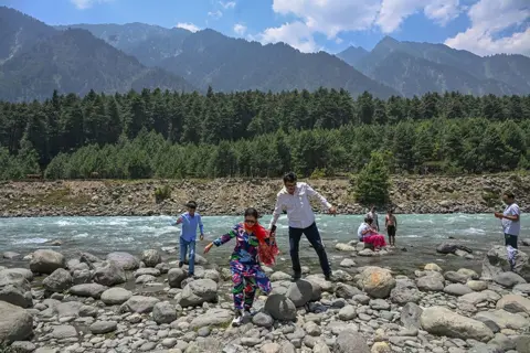 Abid Bhat/BBC The Jaffar family enjoy the river in Pahalgam