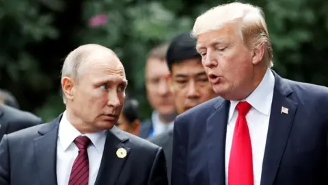 Putin, left, looks at Trump as he speaks