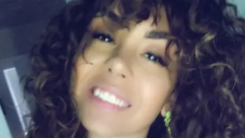 A young woman smiles at the camera