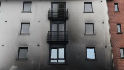 Tejal Samat and Nishath Mohammed A building showing smoke damage to the outside.
