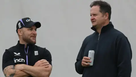 Brendon McCullum left, talks to Rob Key who is holding a drink