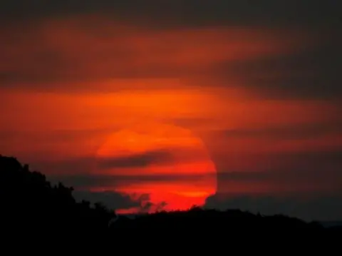 HikerJosh Strawberry Moon close to the horizon glowing red