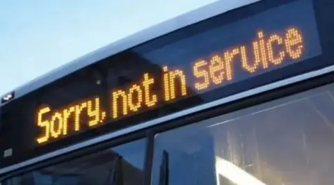 The top of a bus with the ticker: 'Sorry, not in service' clearly visible.