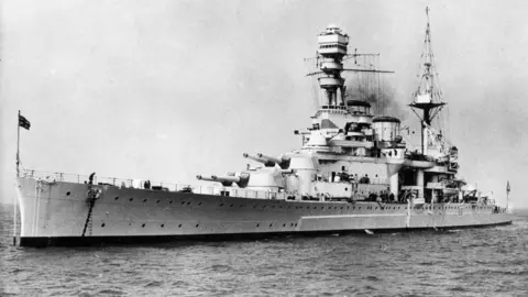 Royal Navy A black and white archive picture of HMS Repulse sailing across the sea. It is a large white military vessel with various lookouts and weapons protruding from its hull.