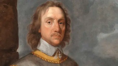 Cromwell Museum/Simon Hill An artist's painting of Oliver Cromwell. He has long brown hair and is wearing a collared grey tunic.