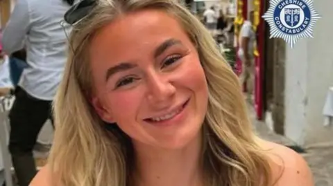 Lucy Harrison, who has long blonde hair and a pair of sunglasses perched on the top of her head, smiles at the camera