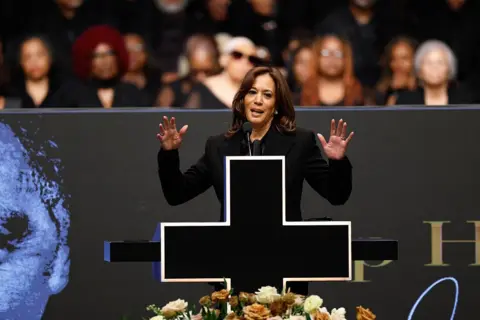 Getty Images Harris is seen on stage, with two hands up as she speaks about Jackson.