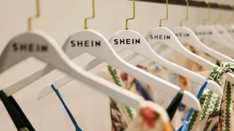 Summer dresses with Shein-branded hangers displayed on a clothes rack