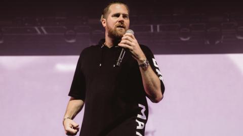 Basshunter on stage with mic in hand