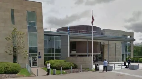 A modern looking building with people outside 