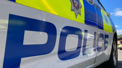 A Wiltshire Police car photographed up close from the side.