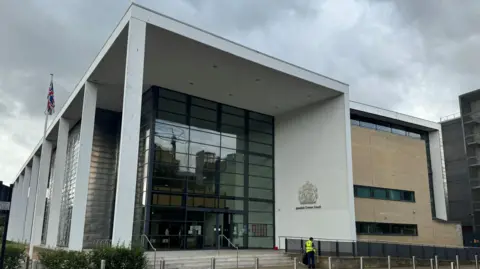 George King/BBC The beforehand   entranceway  to Ipswich Crown Court - a ample  gathering  with a solid  frontage, bordered by a achromatic  structure.
