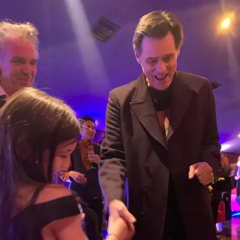 Safi Zisman Actor Jim Carrey is shaking hands with Ruby while looking at her painting