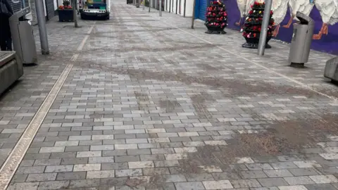 Slurry spread in a zig-zag pattern down a pedestrian street.